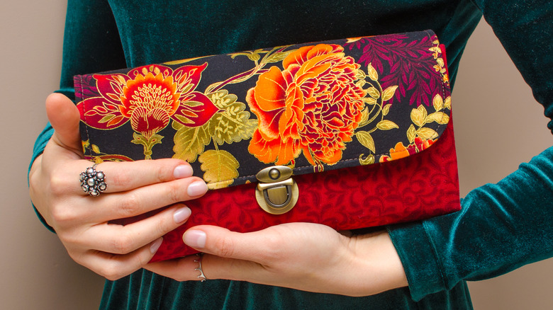 Model holding floral clutch