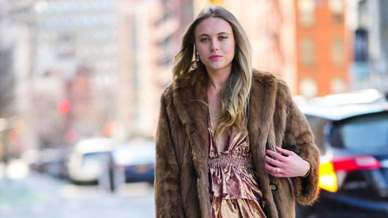 Individual wearing a coat over a floral dress