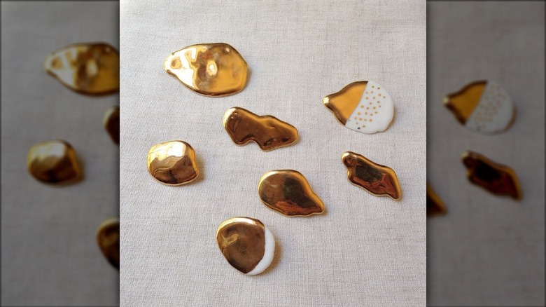 Gold and porcelain brooches against background