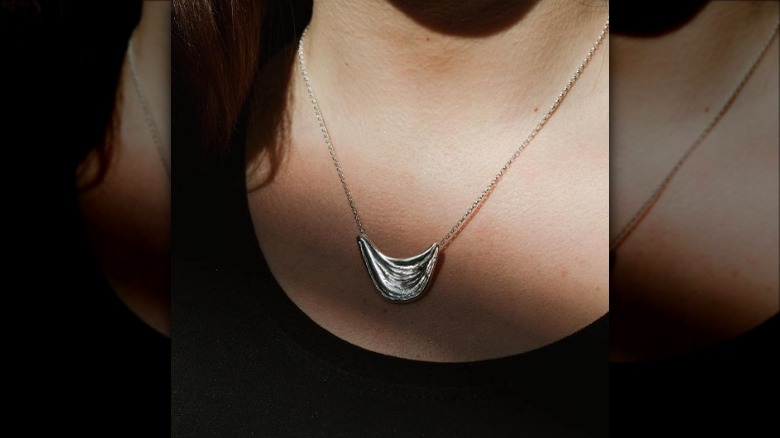 Individual wearing melted silver pendant necklace