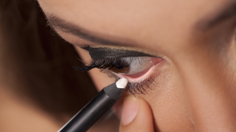 woman applying eye pencil