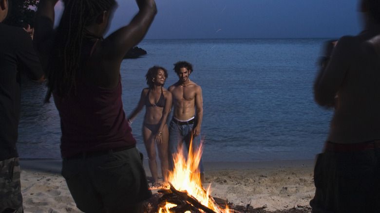 A couple at a bonfire beach party