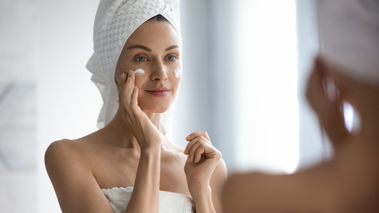 woman applying moisturizer