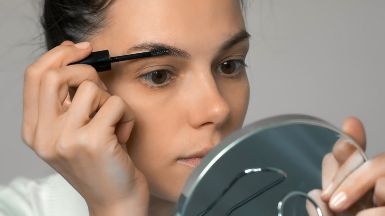 Woman brushing brows with gel