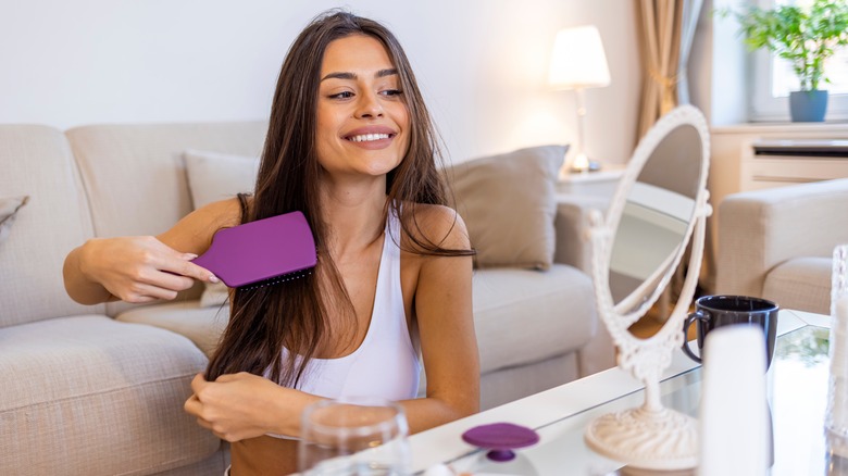 woman using paddle brush on straight hair