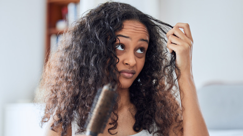 woman with frizzy hair holding brush