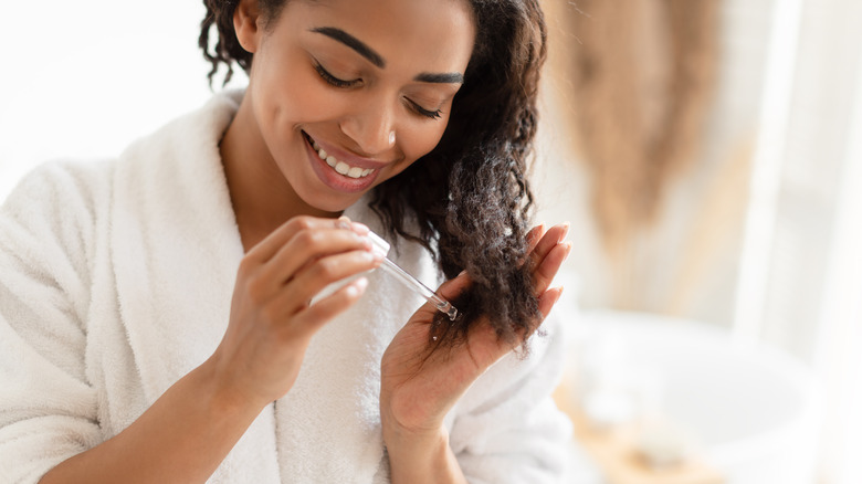 woman applying oil to hair