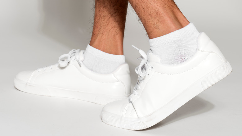 man wearing white socks with white leather sneakers