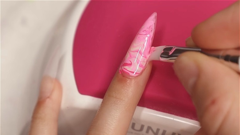 Applying long pink fancy gel nails