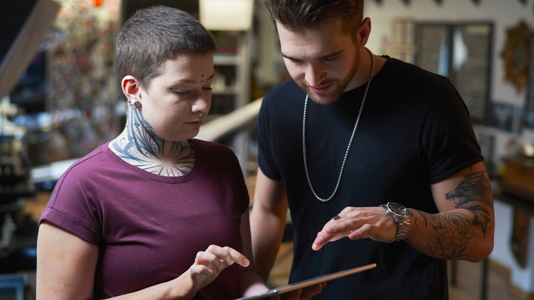 tattoo artist discussing with client