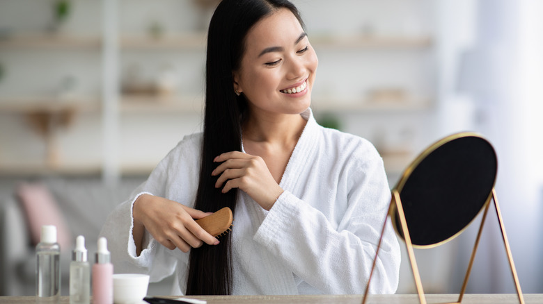 Woman using curved hairbrush