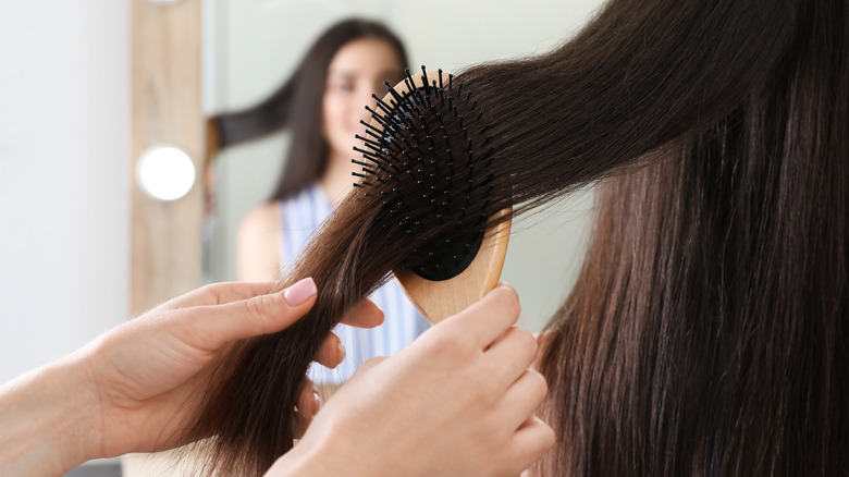 Woman using cushion hairbrush