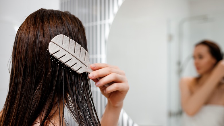 Woman using detangler hairbrush