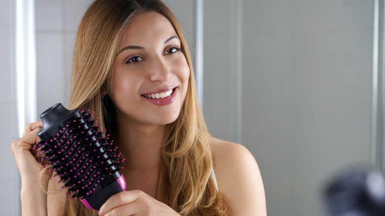 Woman using straightening hairbrush