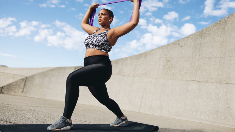 Woman doing lunges with resistance band