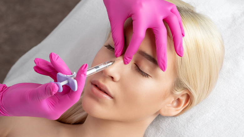 Woman getting nose filler injection