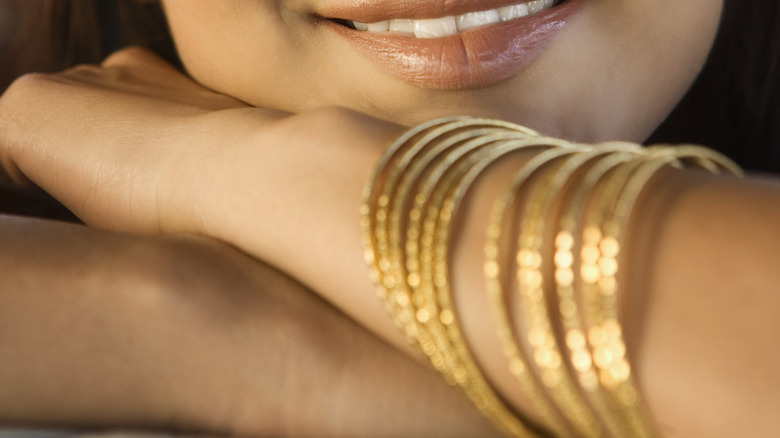 stack of gold bracelets on arm