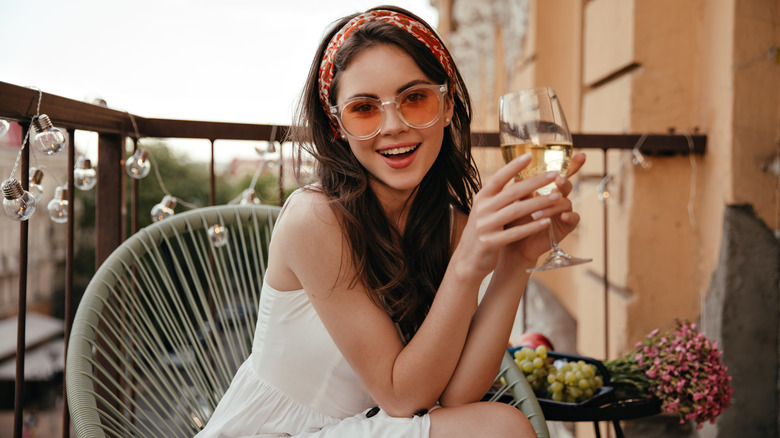 woman wearing white holding glass of wine
