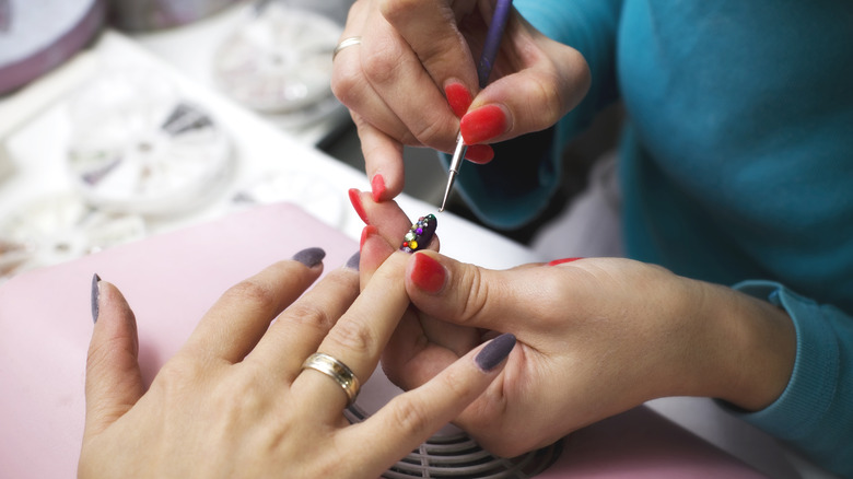 nail artist applying nail gems