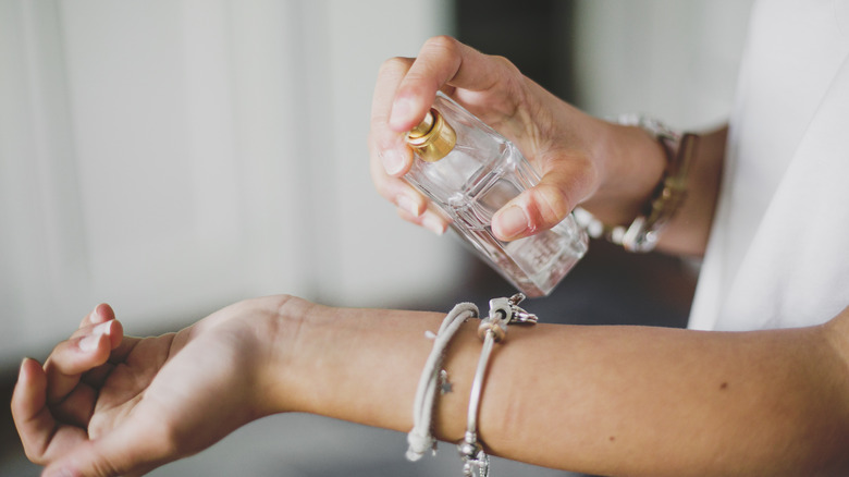 woman applying perfume to wrist