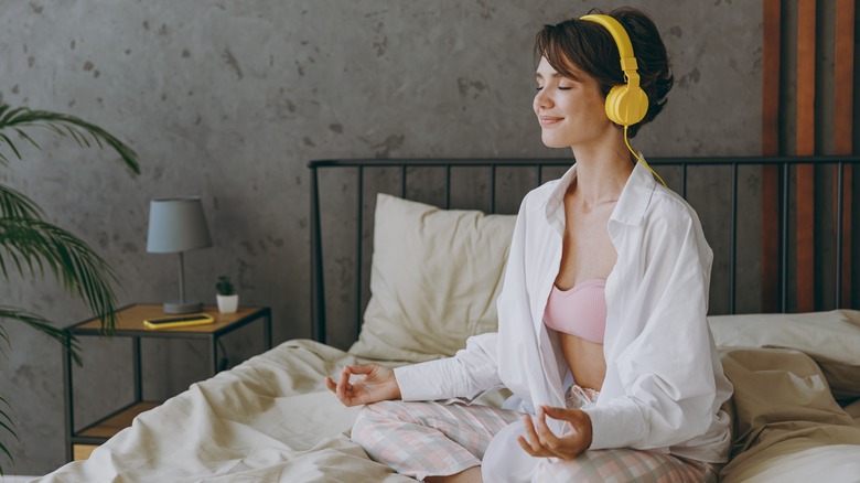 woman meditating on bed