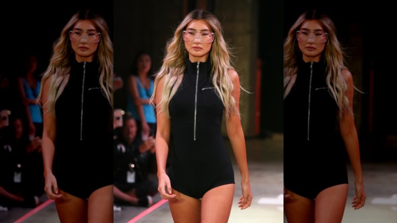 Model wearing black zip-front swimsuit