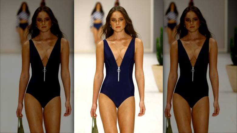 Model wearing blue zip-front swimsuit