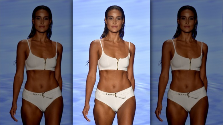 Model wearing white zip-front swimsuit