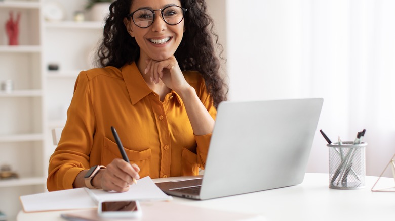 Woman taking notes at laptop