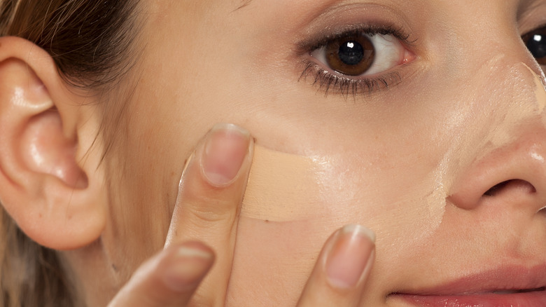 woman applying makeup on face