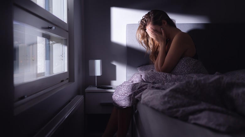 stressed woman sitting on bed